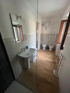 bagno con lavandino e doccia in vetro di Casa Aldobrandeschi Saturnia a Saturnia