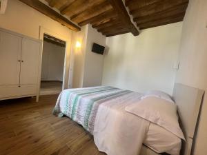 una camera con un letto in una stanza con pavimenti in legno di Casa Aldobrandeschi Saturnia a Saturnia