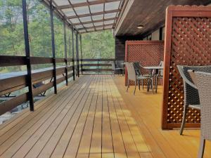 a deck with chairs and tables on a building at Nidos kempingas in Nida