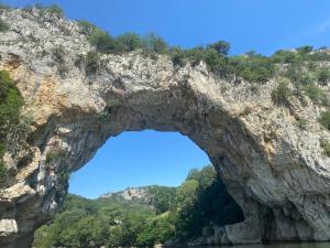 un arco en una formación rocosa en el agua en Le Belvedere, en Vallon-Pont-dʼArc