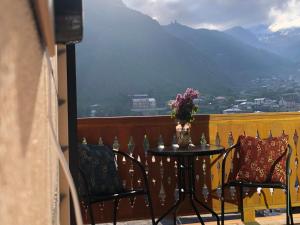 d'une table et de chaises sur un balcon avec vue. dans l'établissement Fiten house, à Kazbegi