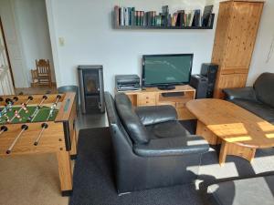 a living room with a ping pong table and a television at Monteurzimmer bei der Gärtnerei in Grünendeich