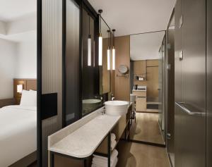 ein Bad mit einem Waschbecken und einem Bett in der Unterkunft AC Hotel by Marriott Seoul Gangnam in Seoul