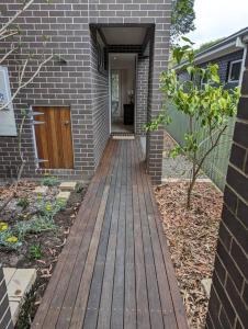 einen Holzsteg, der zu einem Haus mit einer Tür führt in der Unterkunft Bateau Bay Retreat in Bateau Bay