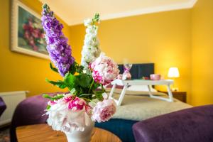 un jarrón lleno de flores rosas y moradas sobre una mesa en Baltvilla, en Baltezers