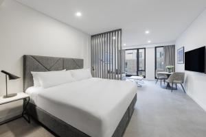 Кровать или кровати в номере Meriton Suites Melbourne