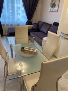 een woonkamer met een glazen tafel en stoelen bij Iva Luxury Apartament in Ruse