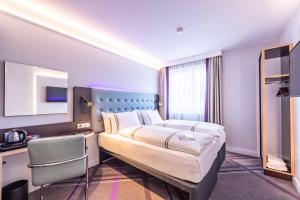 Pokój hotelowy z dużym łóżkiem i biurkiem w obiekcie Premier Inn Nürnberg City Nordost w Norymberdze