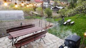 - un banc de parc et un fumoir dans le jardin dans l'établissement Къща До Гората Триград, à Trigrad