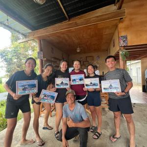 a group of people posing for a picture holding certificates at Achita Cottages in Senaru