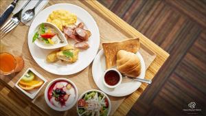 2 assiettes de petit-déjeuner sur une table en bois dans l'établissement Daiwa Roynet Hotel Koriyama Ekimae, à Koriyama