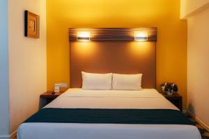 A bed or beds in a room at Hotel Sentral Kuantan @ Riverview City Centre