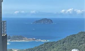 uma vista para o oceano e uma ilha na água em 95 Pavilion em Jiufen