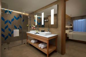 baño con lavabo, espejo y cama en Hyatt Place Jaipur Malviya Nagar, en Jaipur