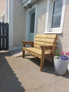 een houten bank voor een gebouw bij Grá na Farraige in Enniscrone