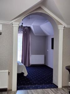 um arco num quarto com uma cama e uma janela em Вiлла Тераса em Polyana