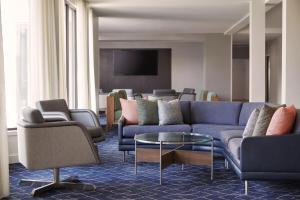 Courtyard by Marriott St. Louis Downtown West في سانت لويس: غرفة معيشة مع أريكة وكراسي زرقاء