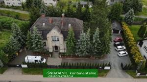 a house with cars parked in a parking lot at Dworek pod świerkami in Jelenia Góra