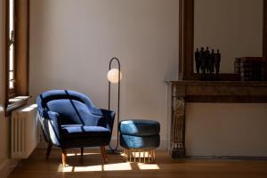 a living room with a blue chair and a lamp at Sapphire House Antwerp, Autograph Collection in Antwerp