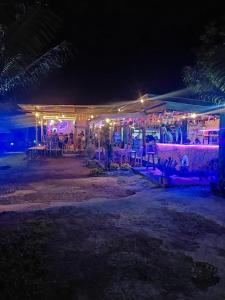 a restaurant at night with lights on a beach at Achita Cottages in Senaru