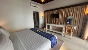 a hotel room with a bed and a desk at Living Asia Resort and Spa in Senggigi 