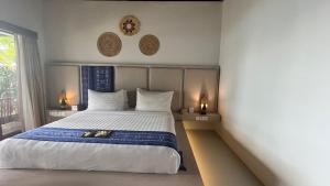 a bedroom with a large bed and a window at Living Asia Resort and Spa in Senggigi 