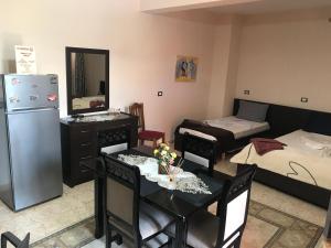 a living room with a table and chairs and a refrigerator at Maison Centre in Shkodër