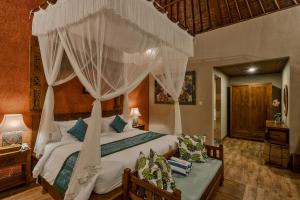 1 dormitorio con 1 cama con dosel en Teja Lokha Ubud Villa, en Ubud