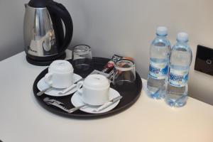 a table with a tray with cups and bottles of water at Ultramarinn Hotel in Odesa