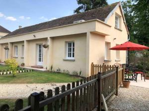 uma casa com uma cerca e um guarda-chuva vermelho em Riverside Lodge em Chablis