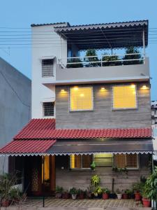 uma casa com um toldo vermelho à frente dela em Myra's house em Colhapur