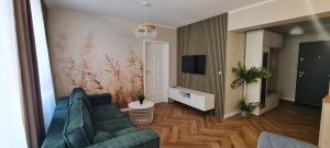 ein Wohnzimmer mit einem Sofa und einem TV in der Unterkunft Mazovia Gold Apartament 101 in Płock