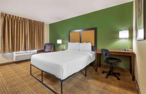 um quarto de hotel com uma cama, uma secretária e uma cadeira em Extended Stay America Suites - Indianapolis - Airport em Indianápolis