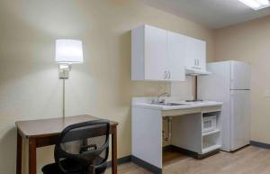 uma pequena cozinha com uma secretária e um frigorífico branco em Extended Stay America Suites - Indianapolis - Airport em Indianápolis