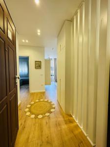 a hallway with a door and a rug on a wooden floor at Madalin Seaside Apartment in Vlorë