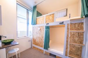 a room with a bunk bed with green curtains at KIZUNA HOTEL Gojo Kiyomizu-dera Kamogawa in Kyoto