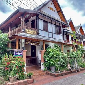 uma casa com um sinal em frente em Nocknoy Lanexang Guest House em Luang Prabang