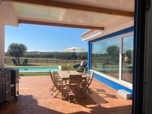 un patio con mesa, sillas y piscina en Casa Bendi, en Cuba