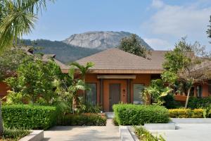 ein Haus mit einem Berg im Hintergrund in der Unterkunft Mulberry Shades Bengaluru Nandi Hills - a Tribute Portfolio Resort in Bangalore