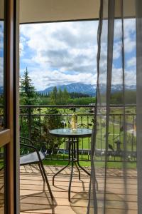 d'une table et de chaises sur un balcon avec vue. dans l'établissement Pokoje Gościnne MAGNAS, à Poronin