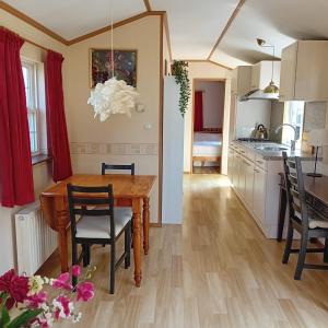 a kitchen and dining room with a wooden table and chairs at Slapen op De Bult Green 2 persons in De Bult