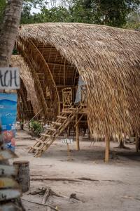 a straw hut with a thatched roof and a staircase at Isla - The Island Experience in El Nido