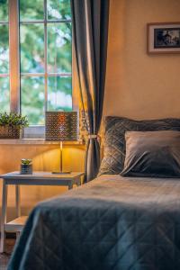 a bedroom with a bed and a table and a window at Willa Skalniak in Lądek-Zdrój