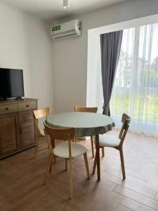 uma sala de jantar com mesa e cadeiras e uma televisão em Modern apartament em Mukachevo