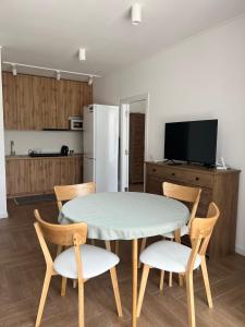 uma cozinha com uma mesa e cadeiras e um frigorífico em Modern apartament em Mukachevo