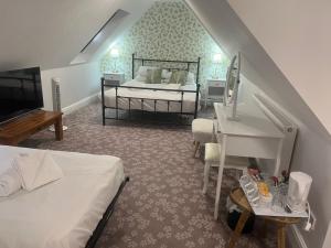 a bedroom with two beds and a piano in a room at Penny Farthing Hotel & Cottages in Lyndhurst