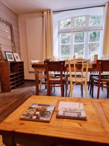 - un salon avec une table en bois et une salle à manger dans l'établissement LES REMPARTS DU JERZUAL, à Dinan