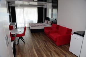 ein Wohnzimmer mit einem roten Sofa und einem Bett in der Unterkunft Velestovo View Apartments in Ohrid