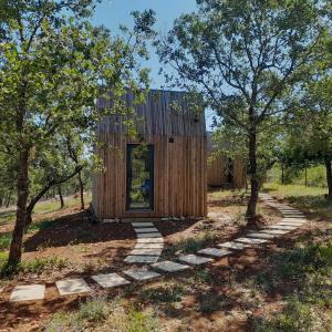 a small wooden house in a field with trees at Refugio do Carrascal in Tomar