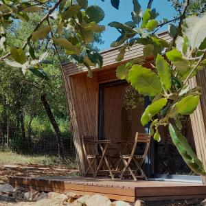 a wooden cabin with a chair in front of it at Refugio do Carrascal in Tomar